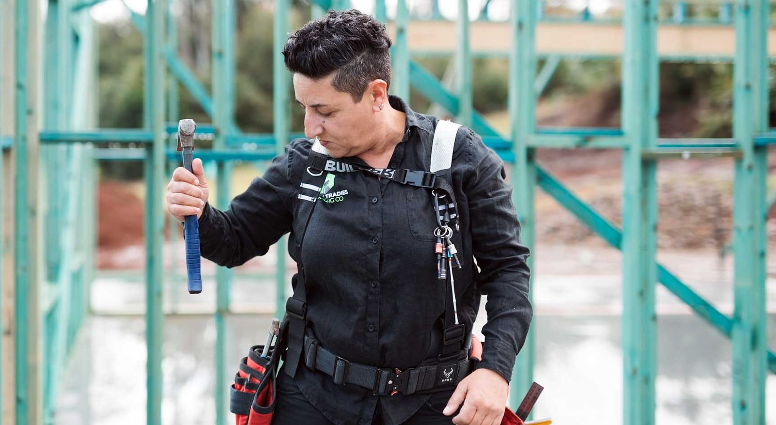 Penn Petridis on a building site, hammer in hand